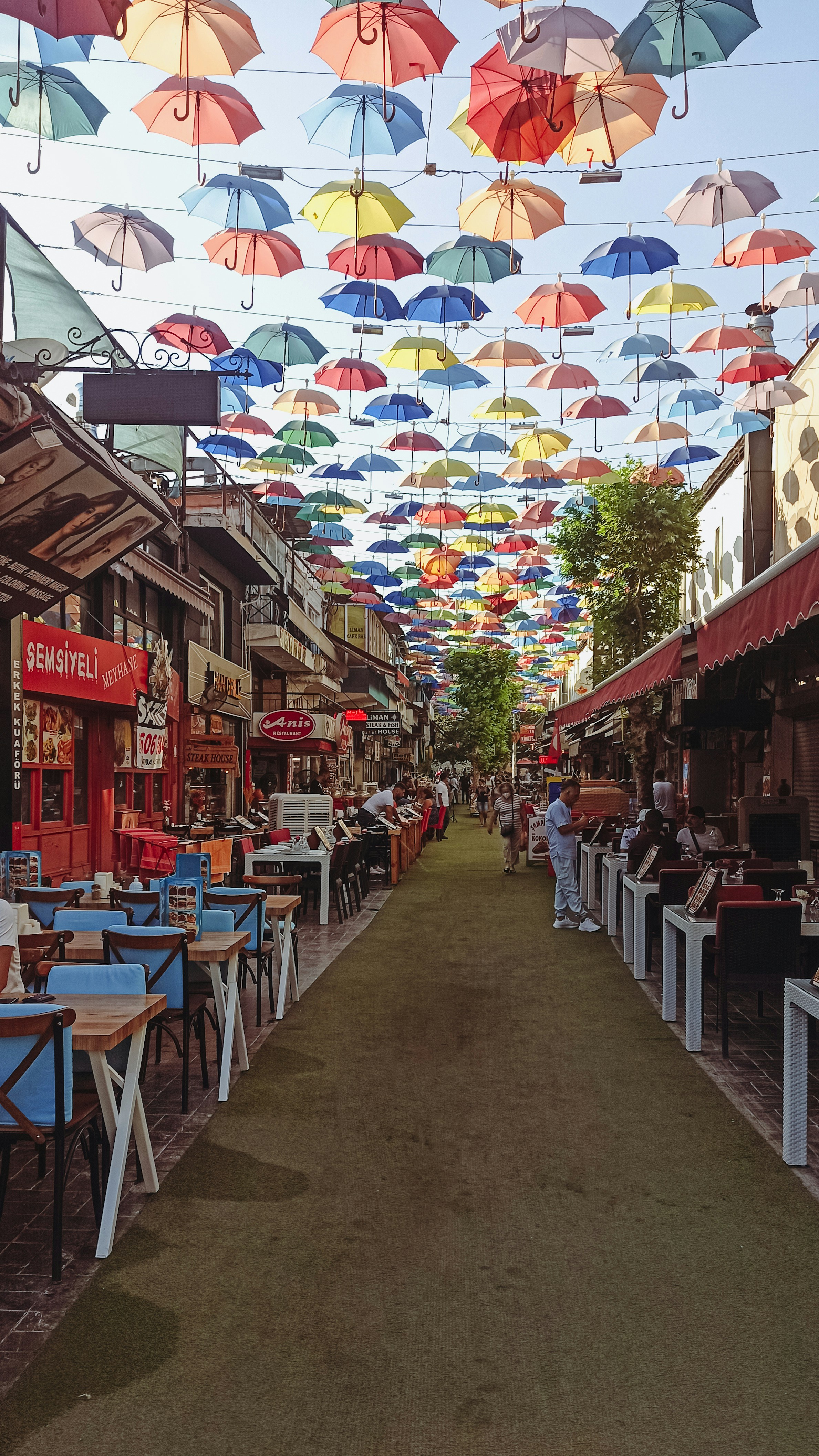 a row of tables with umbrellas hanging above them