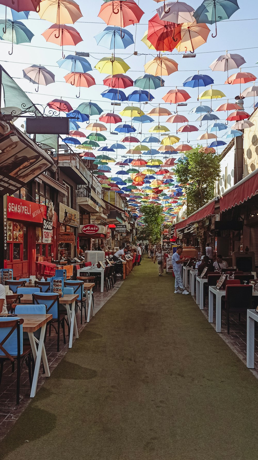 a row of tables with umbrellas hanging above them