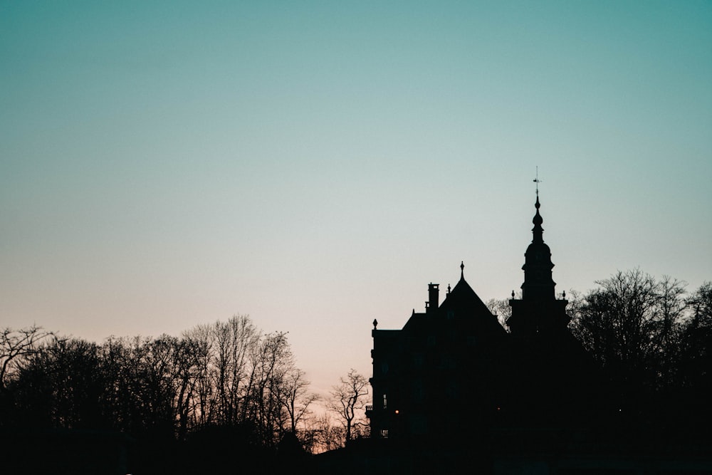 Una silhouette di un edificio con una torre dell'orologio