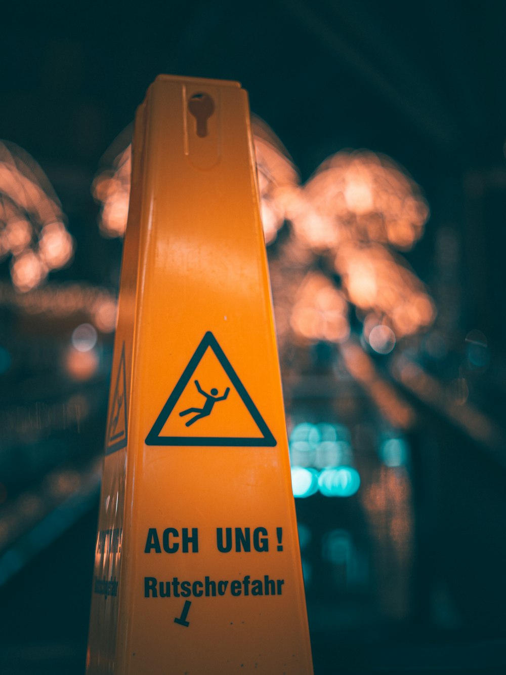 a yellow caution sign sitting on top of a wooden table