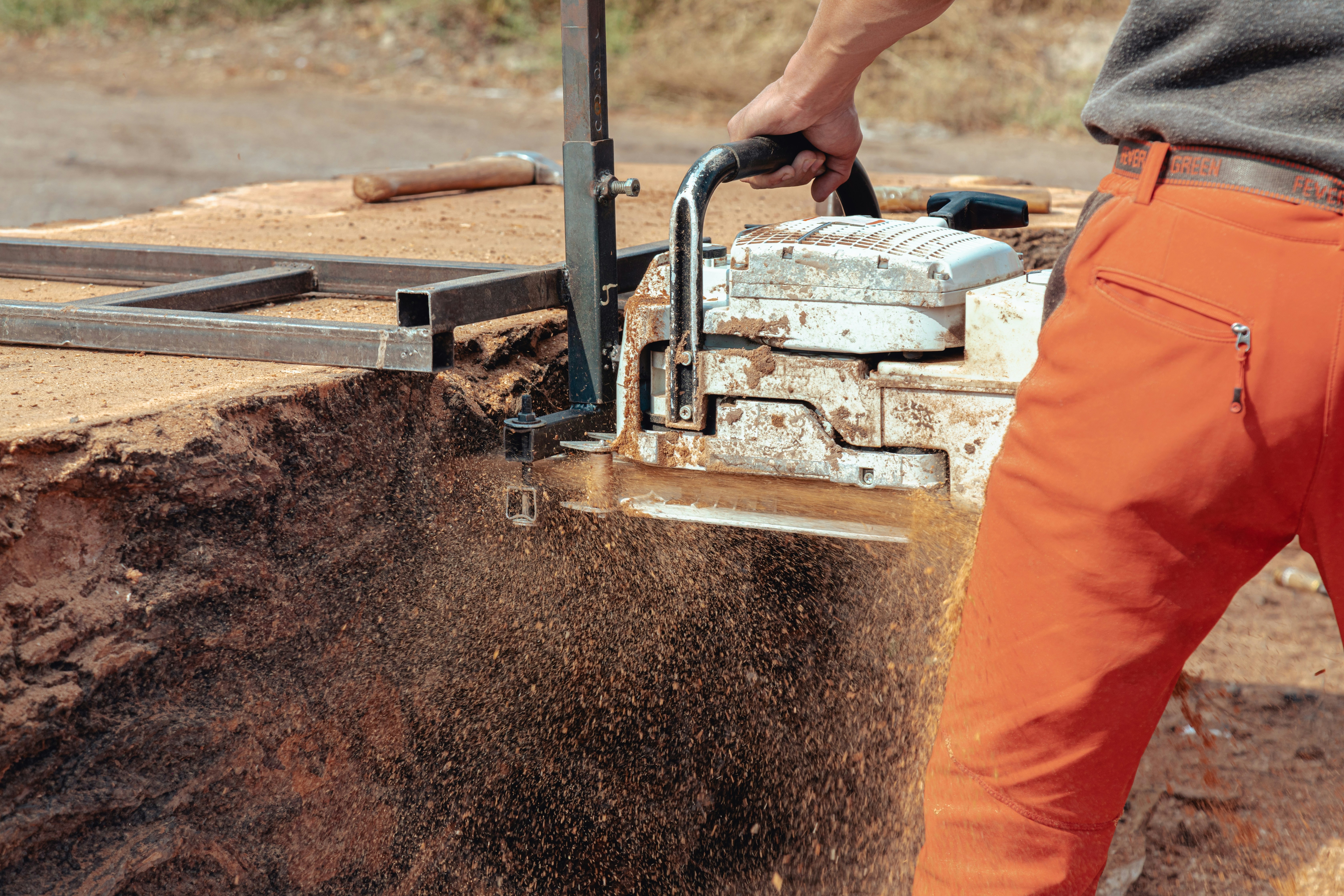 Closeup of a lumberjack cutting tree trunk with the giant chainsaw to make wooden planks