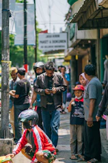 a group of people standing on a street next to each other