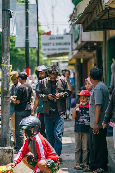 a group of people standing on a street next to each other