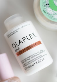 a bottle of olaplex next to a container of lotion