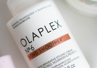 a bottle of olaplex next to a container of lotion