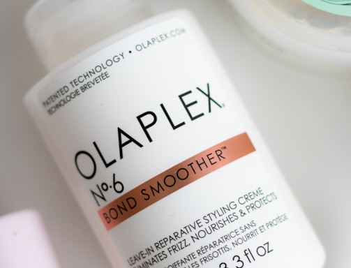 a bottle of olaplex next to a container of lotion