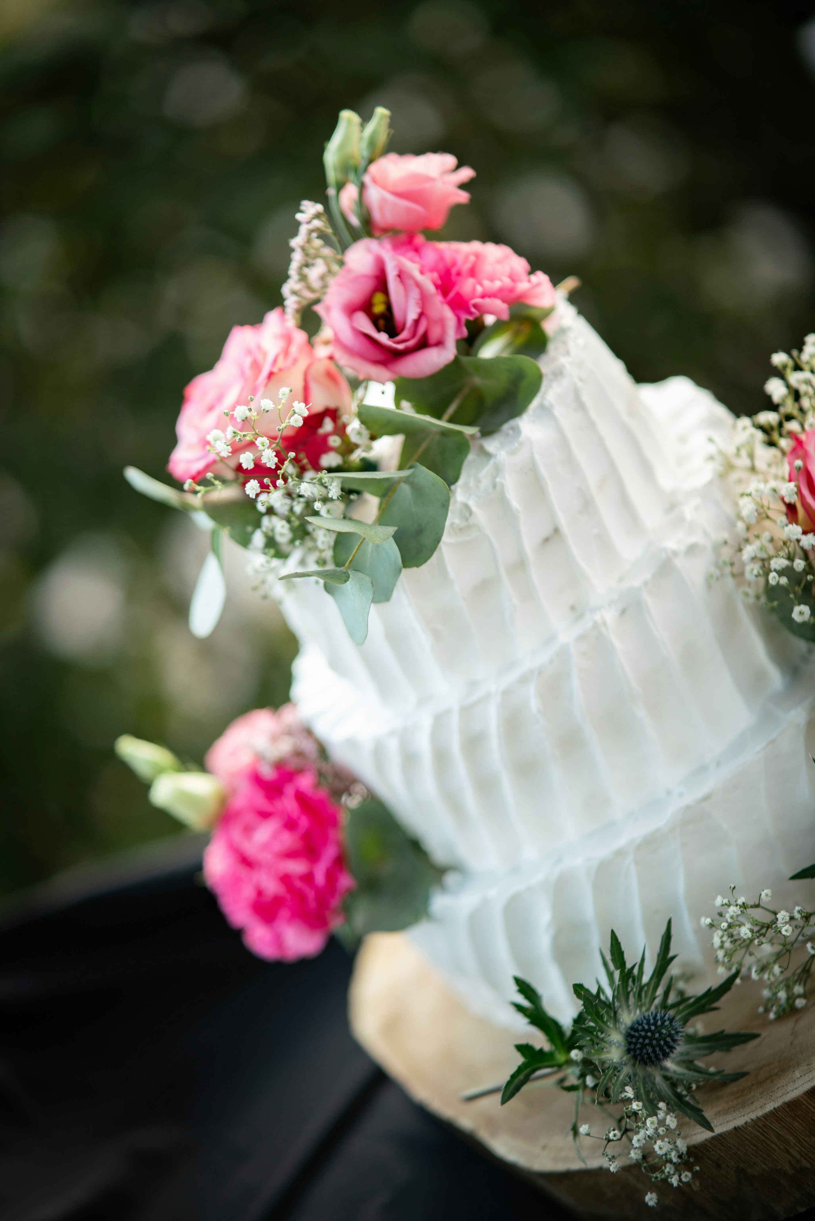 Un gros plan d’un gâteau de mariage avec des fleurs dessus photo ...