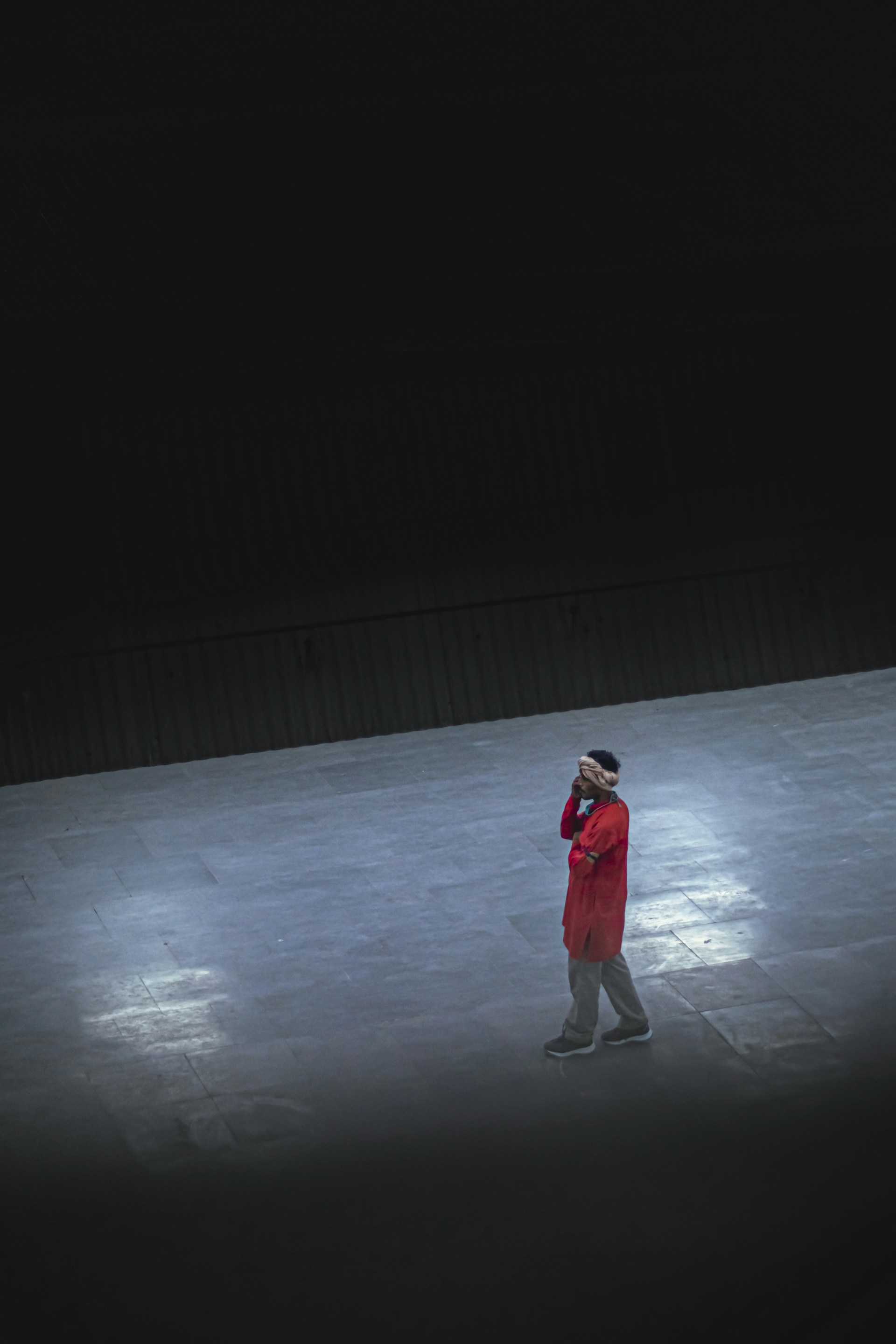a man in a red coat standing in the dark