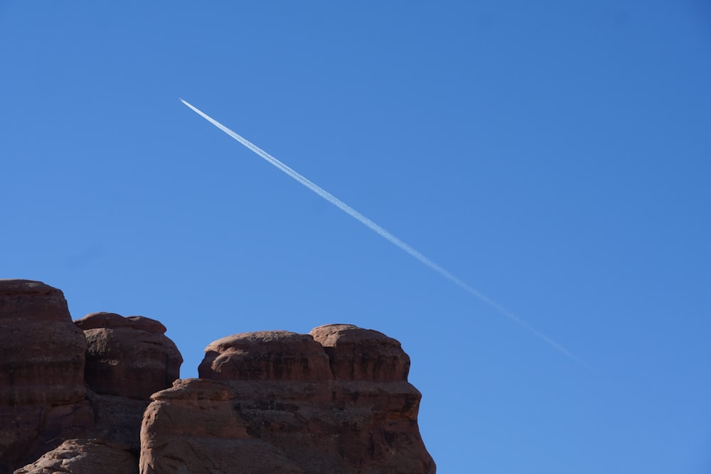 a plane flying over a rocky outcropping