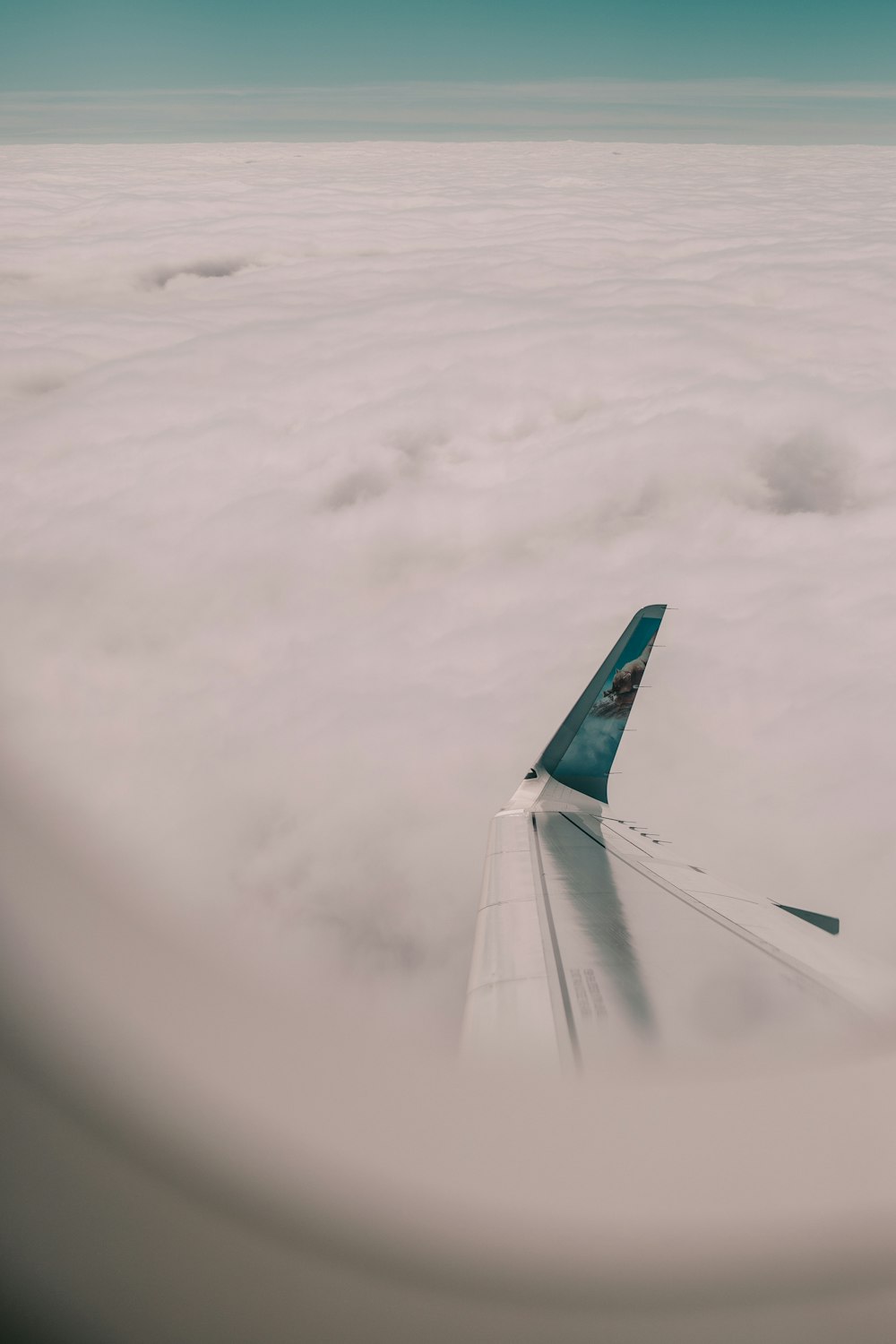 a view of the wing of an airplane above the clouds