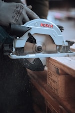 a person using a circular saw to cut a piece of wood