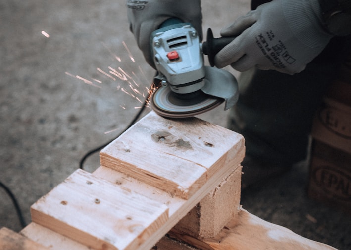 a person using a grinder on a piece of wood