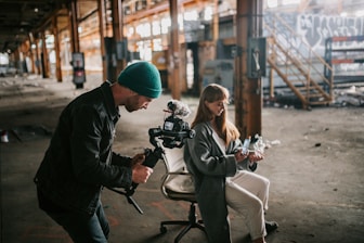 a man standing next to a woman holding a camera