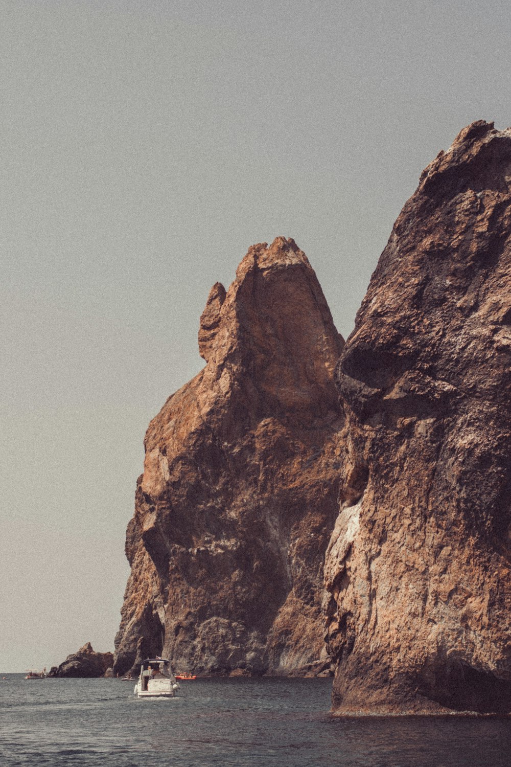 a boat in the water near a large rock formation