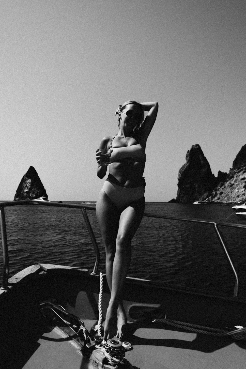 a woman in a bikini standing on a boat