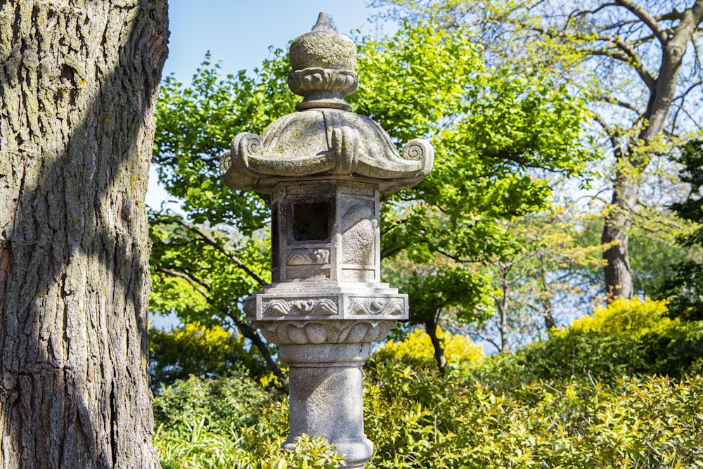 a stone lantern sitting next to a tree