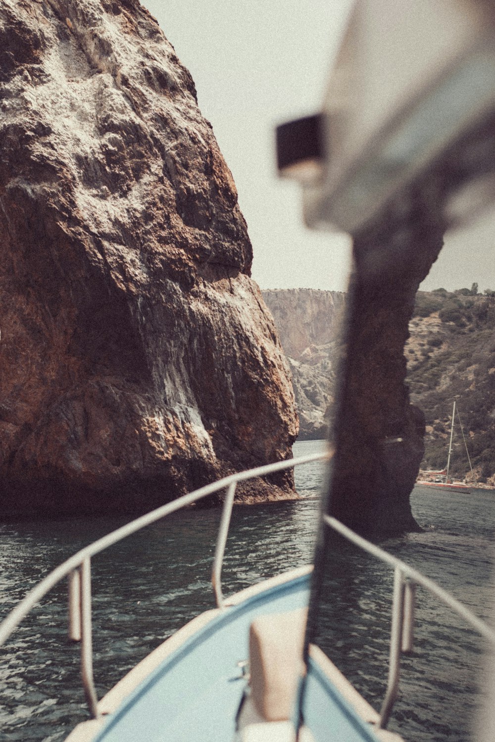 a boat traveling past a large rock formation