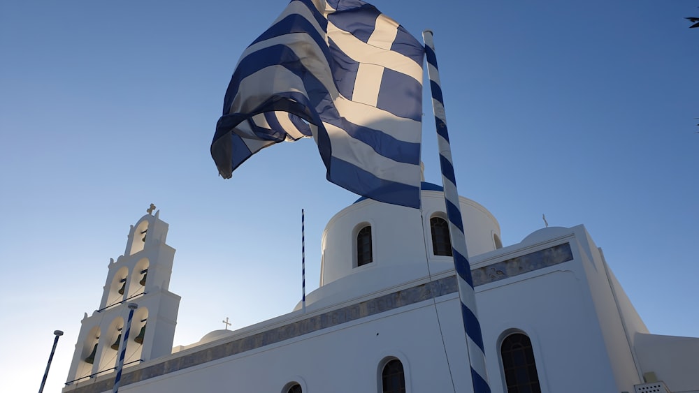 a large greek flag flying in front of a church