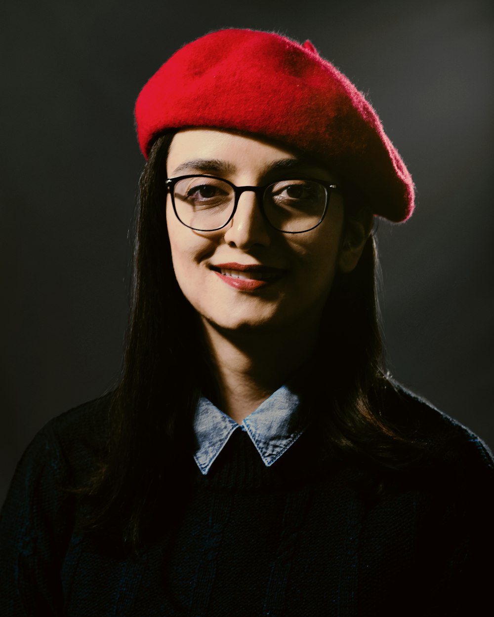 a woman wearing glasses and a red hat