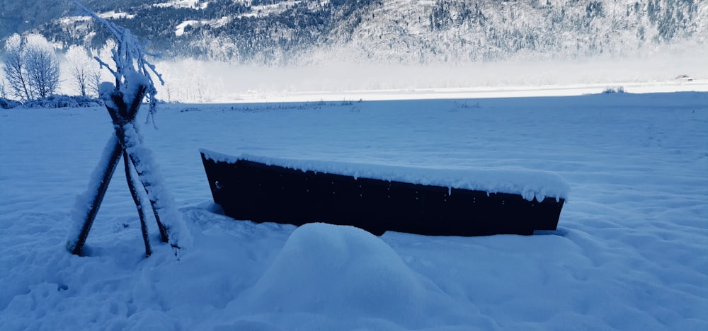 a boat sitting in the middle of a snow covered field