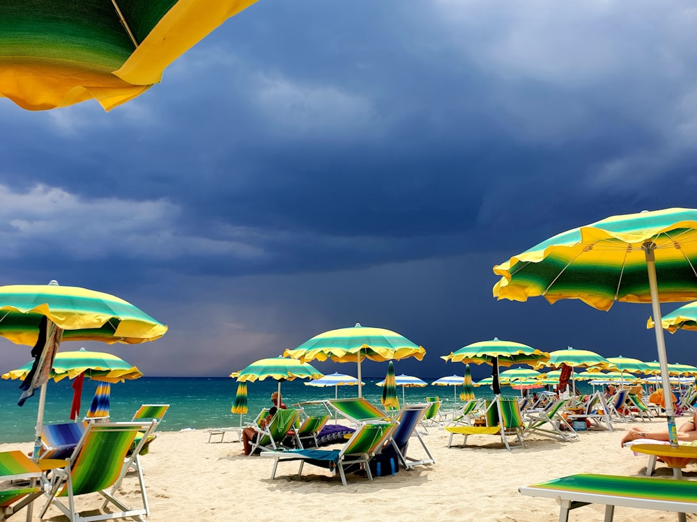 un mucchio di ombrelloni che sono su una spiaggia