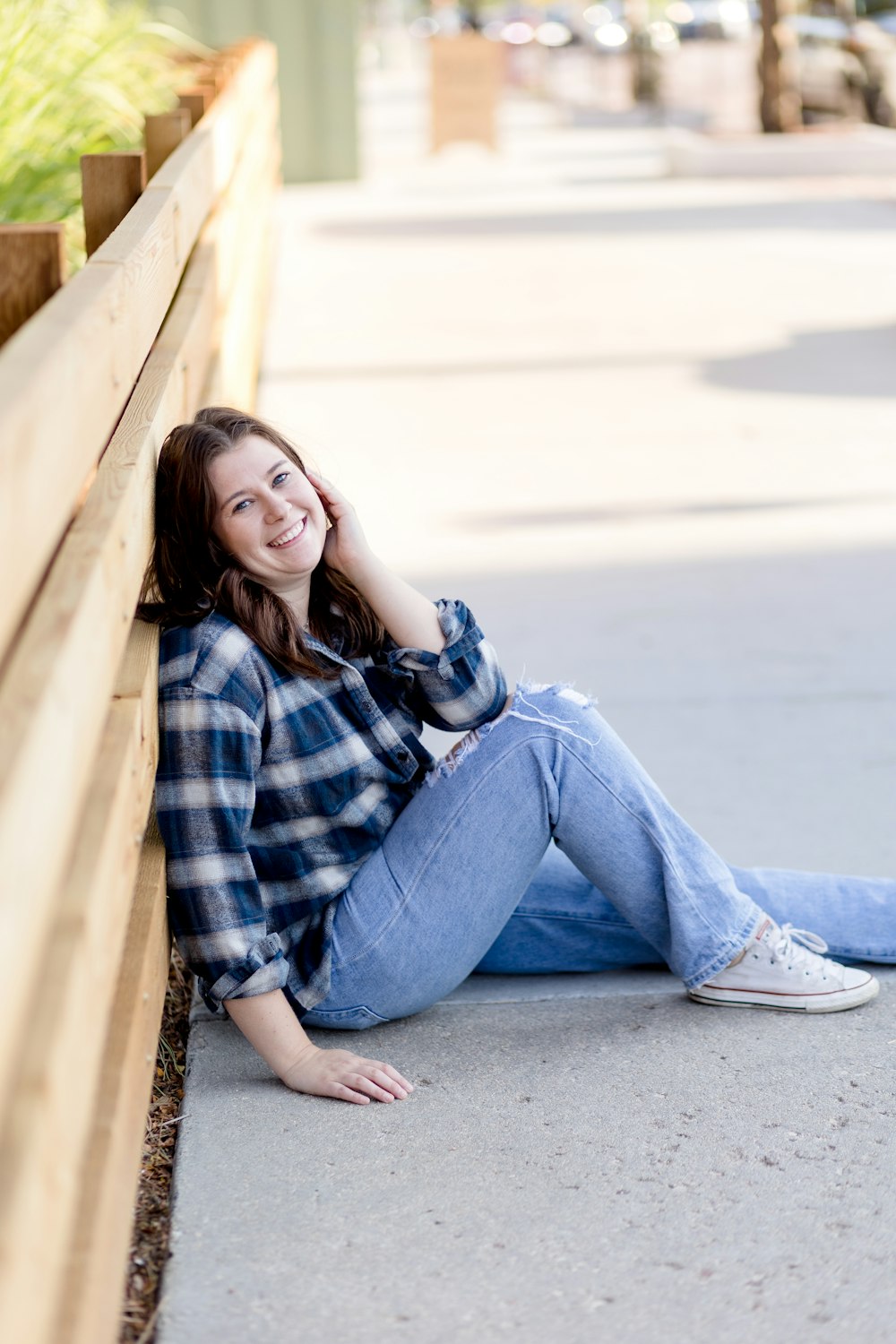 a woman sitting on the side of a wooden bench