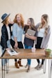 a group of women standing around a wooden table