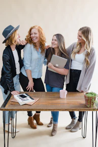 A group of diverse women smiling and working together online during a virtual event.