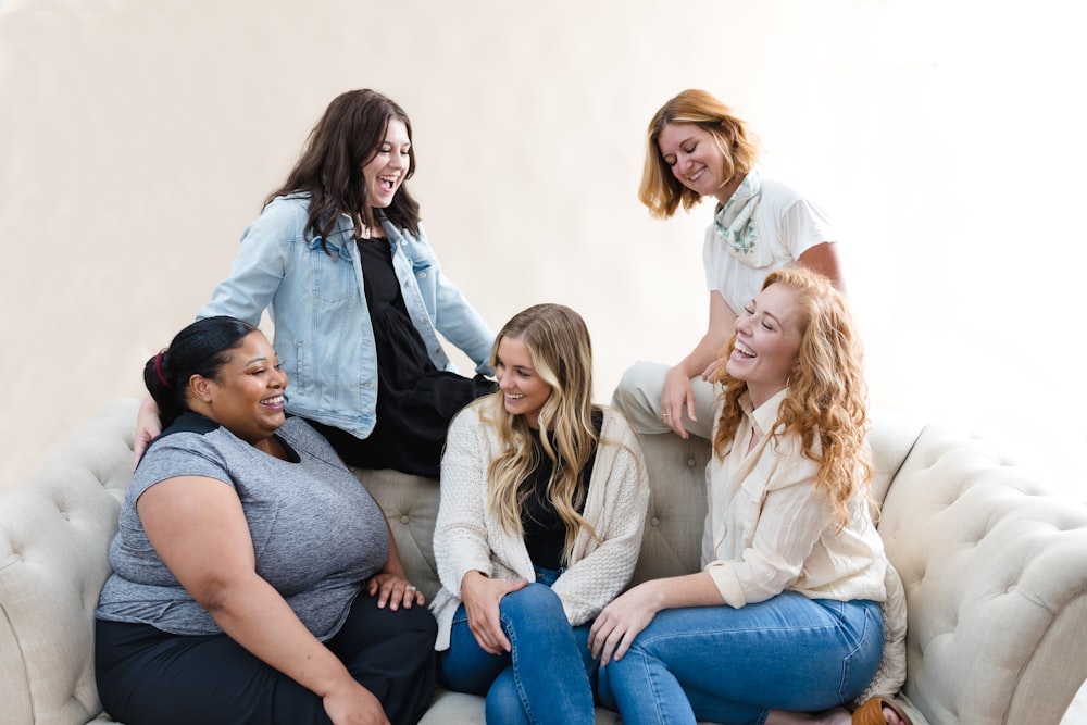 a group of women sitting on top of a couch