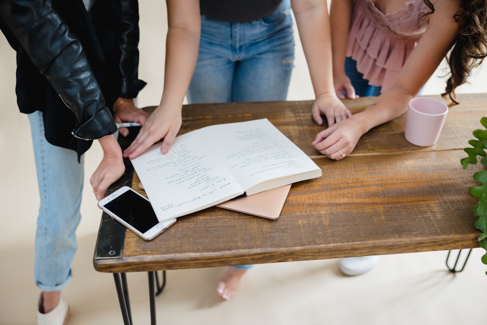 a group of people standing around a wooden table