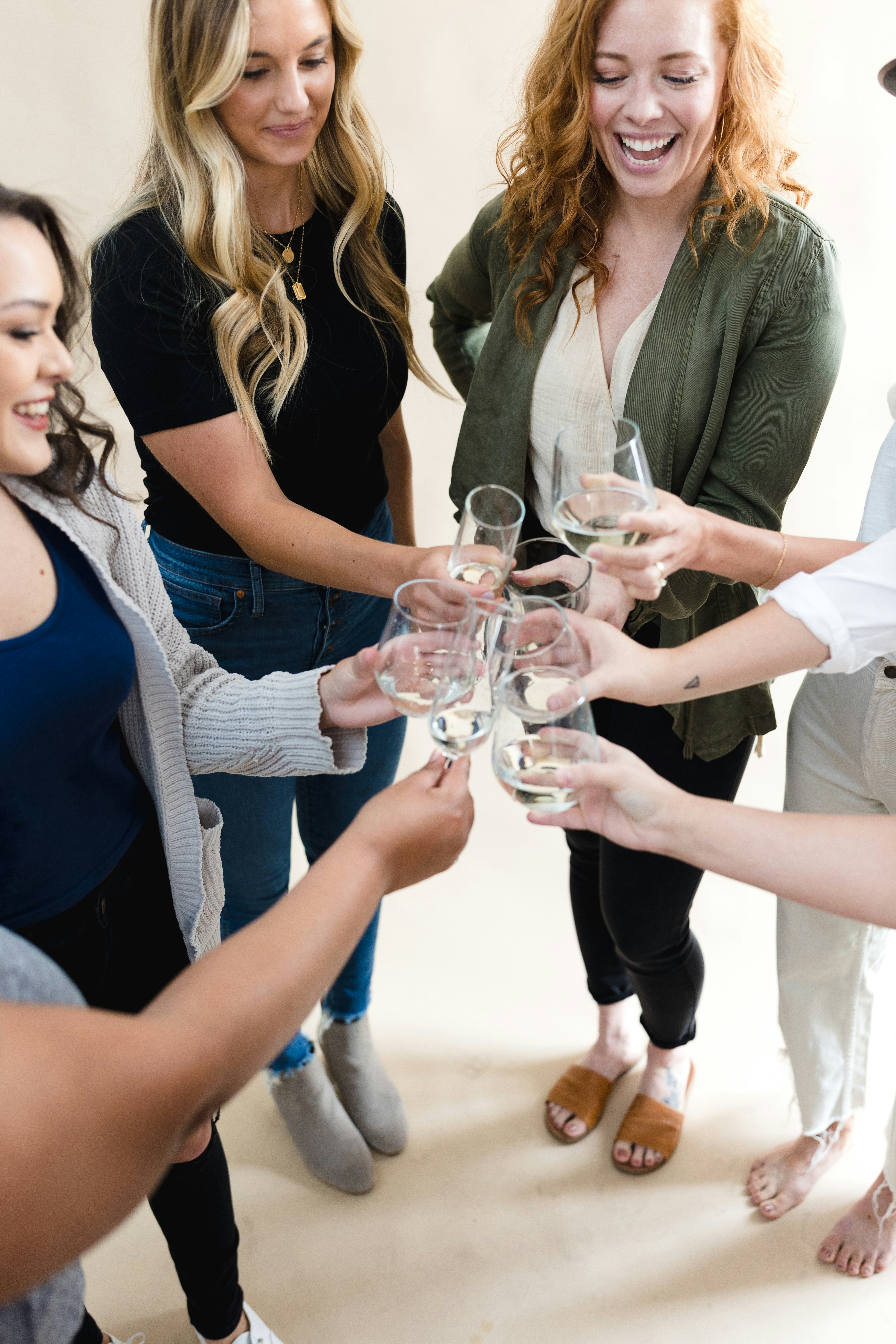 A group of women standing around each other holding wine glasses photo ...