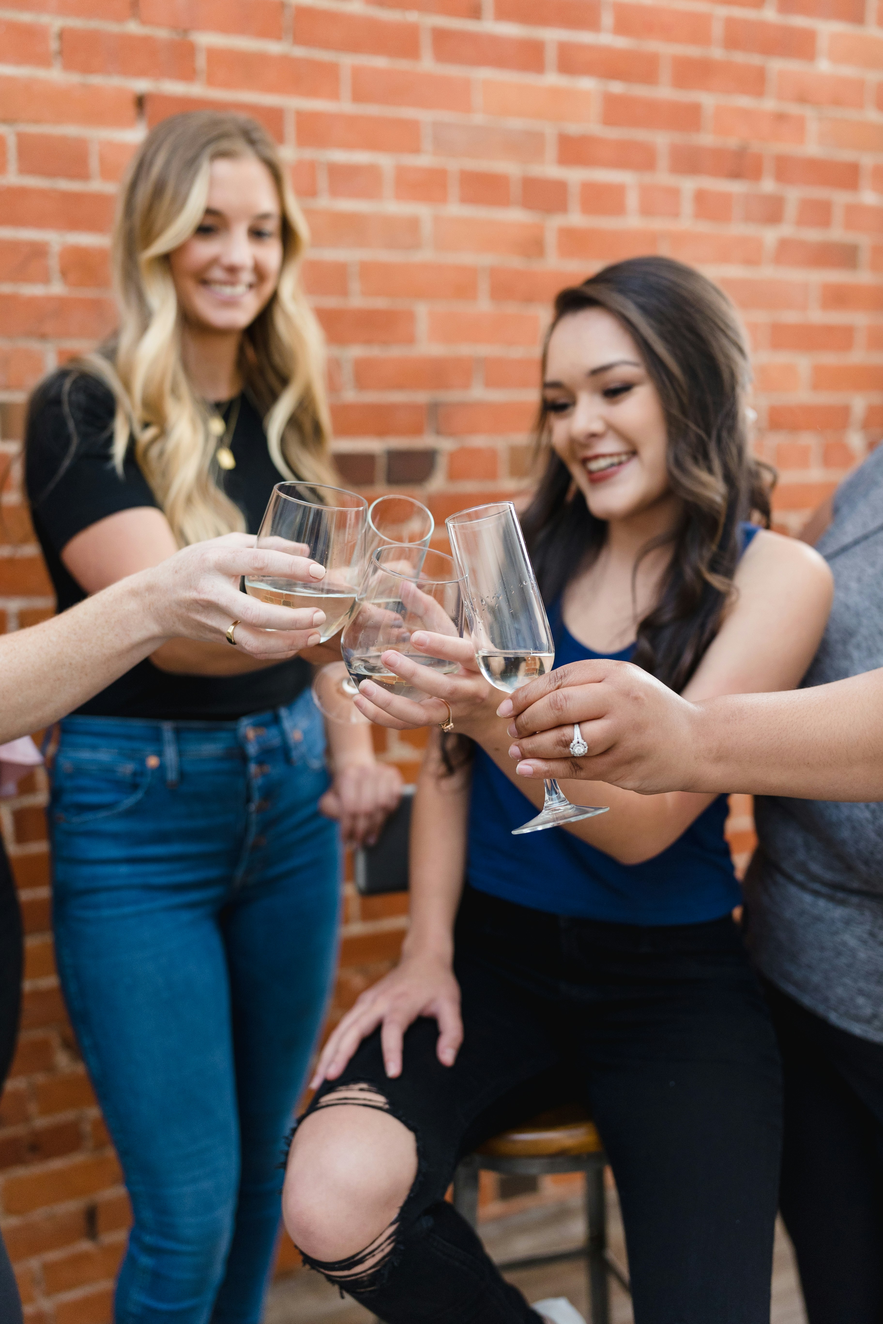 A group of women standing around each other holding wine glasses photo ...