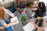 A group of diverse women laughing and sharing ideas around a modern glass table.