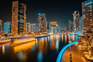 a city at night with a river running through it