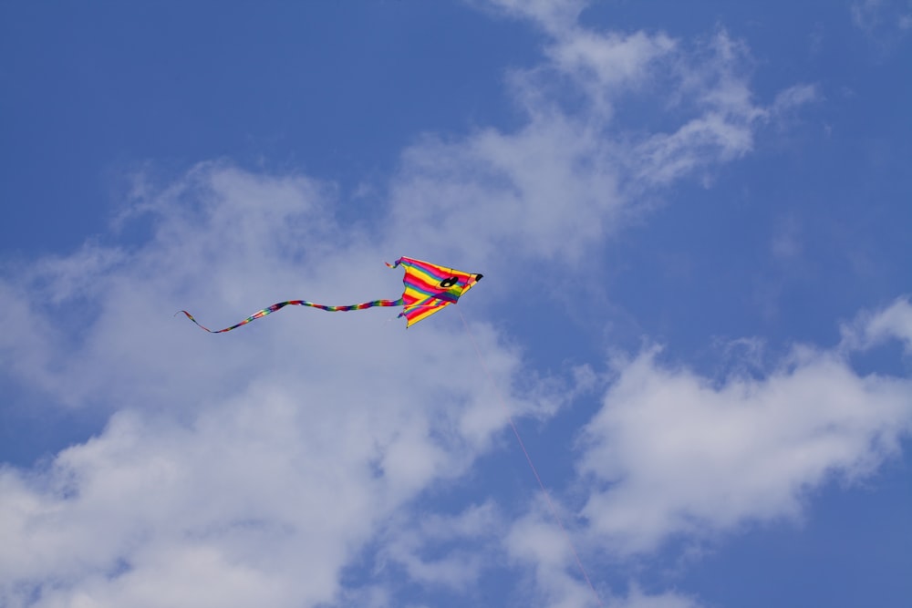 a kite flying high in the sky on a cloudy day