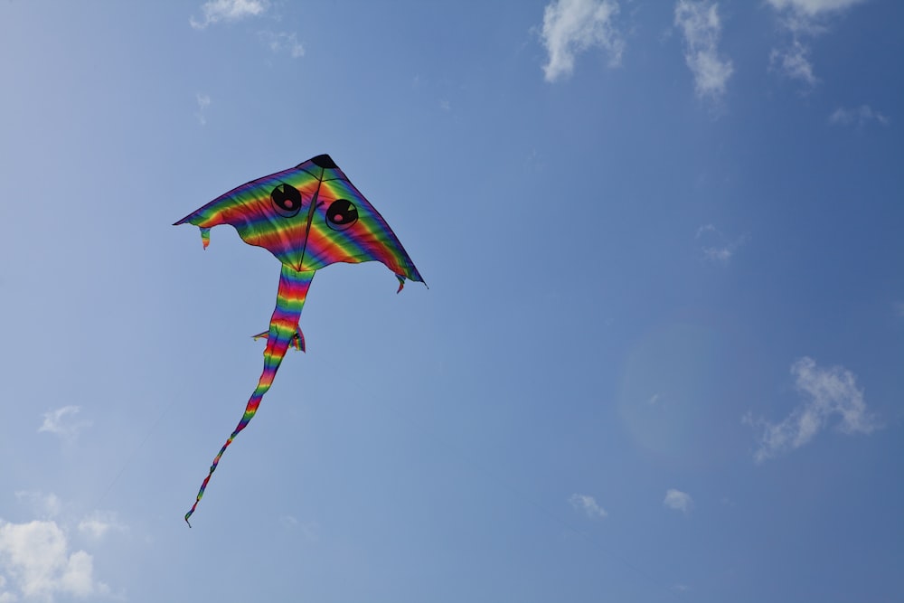 a colorful kite flying through a blue sky