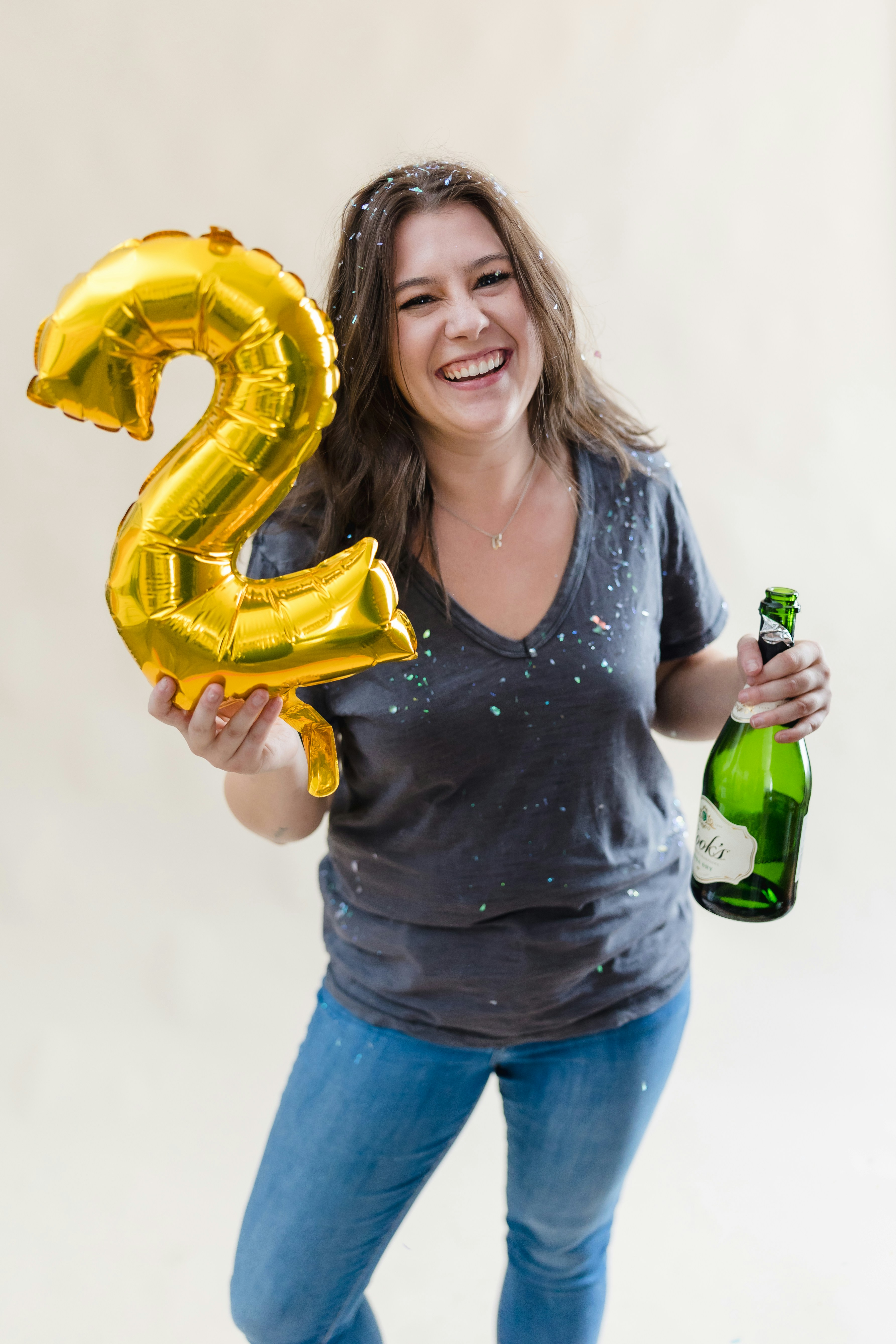 Foto zum Thema Eine Frau hält eine Flasche Bier und einen Ballon Nummer 2 Kostenloses Bild zu