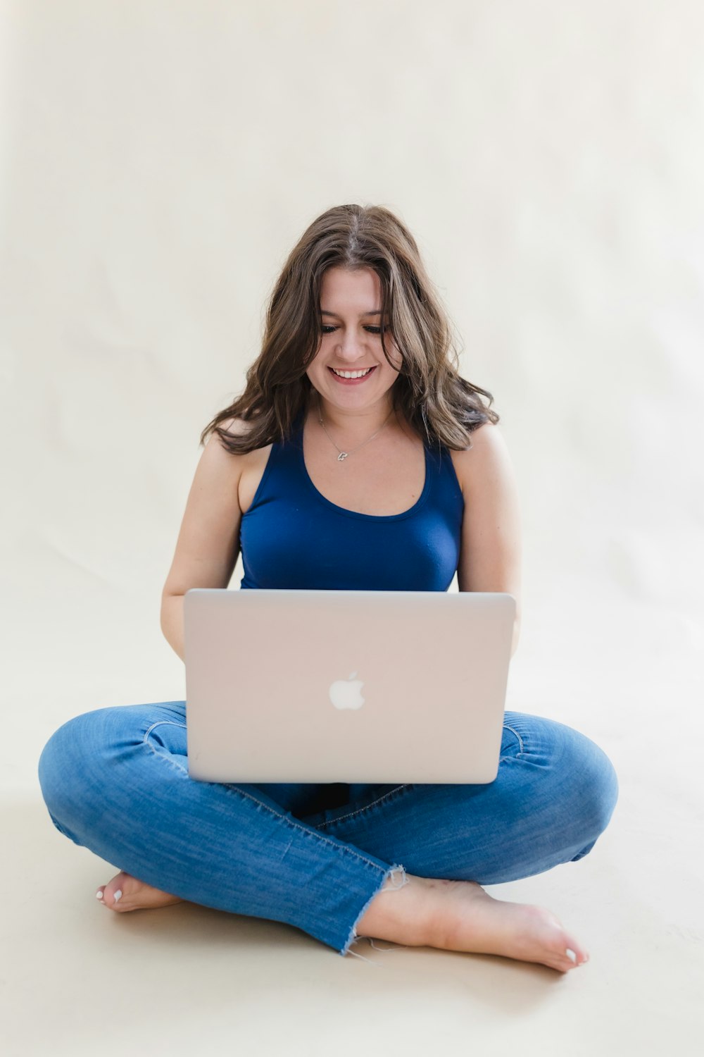 a woman sitting on the floor using a laptop computer