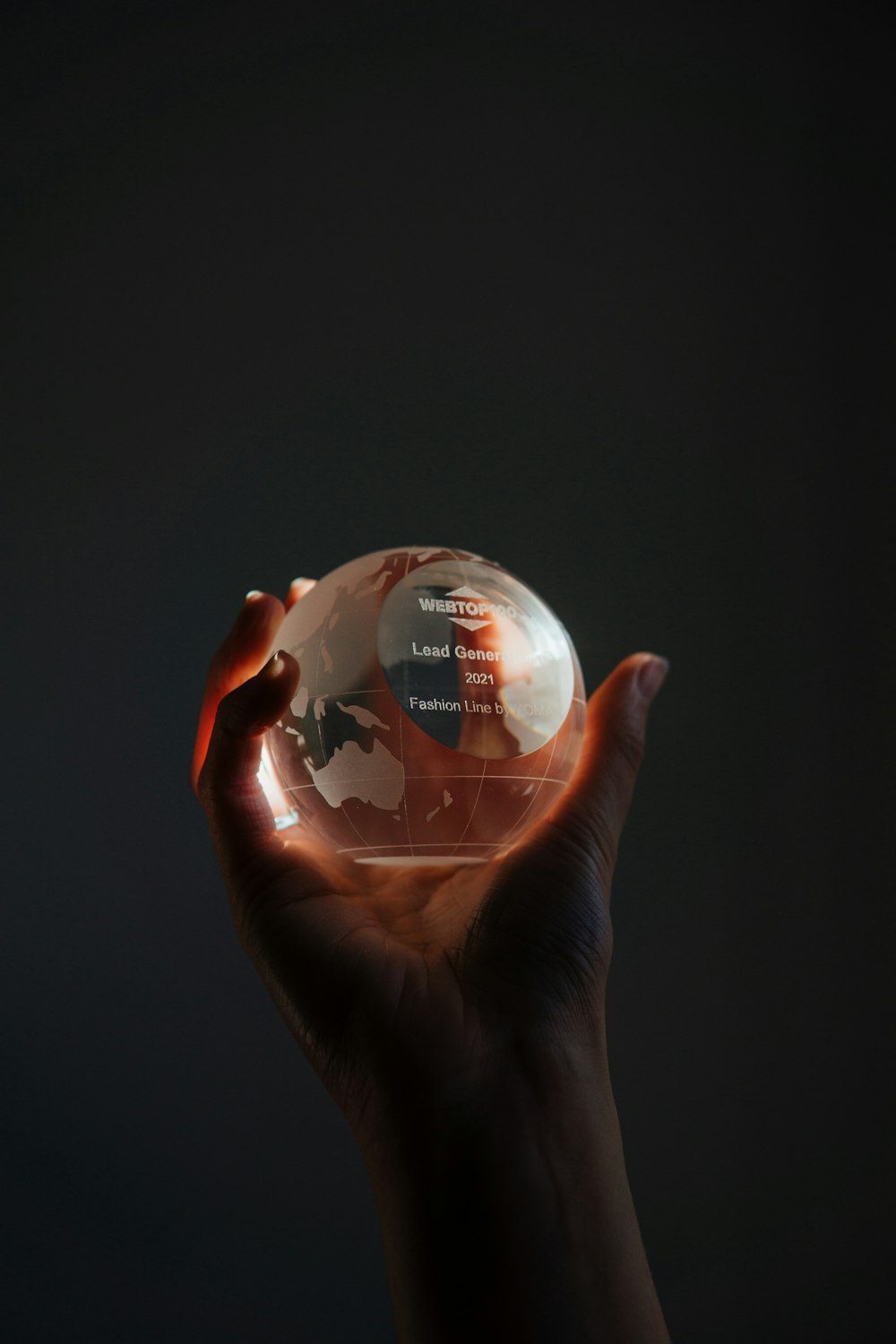 una mano che tiene una sfera di cristallo con una mappa su di essa