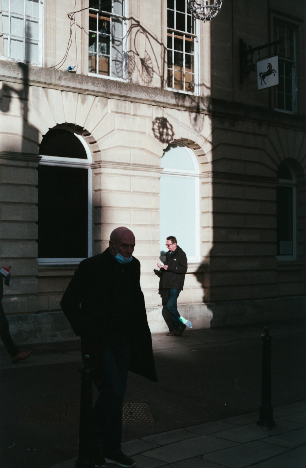 a man standing on a sidewalk in front of a building