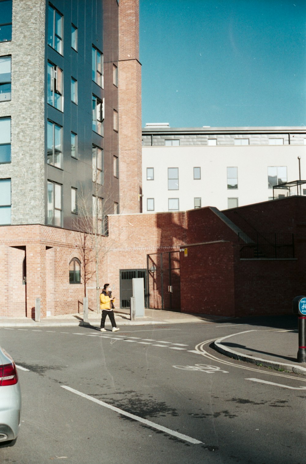 a person crossing a street in front of a tall building