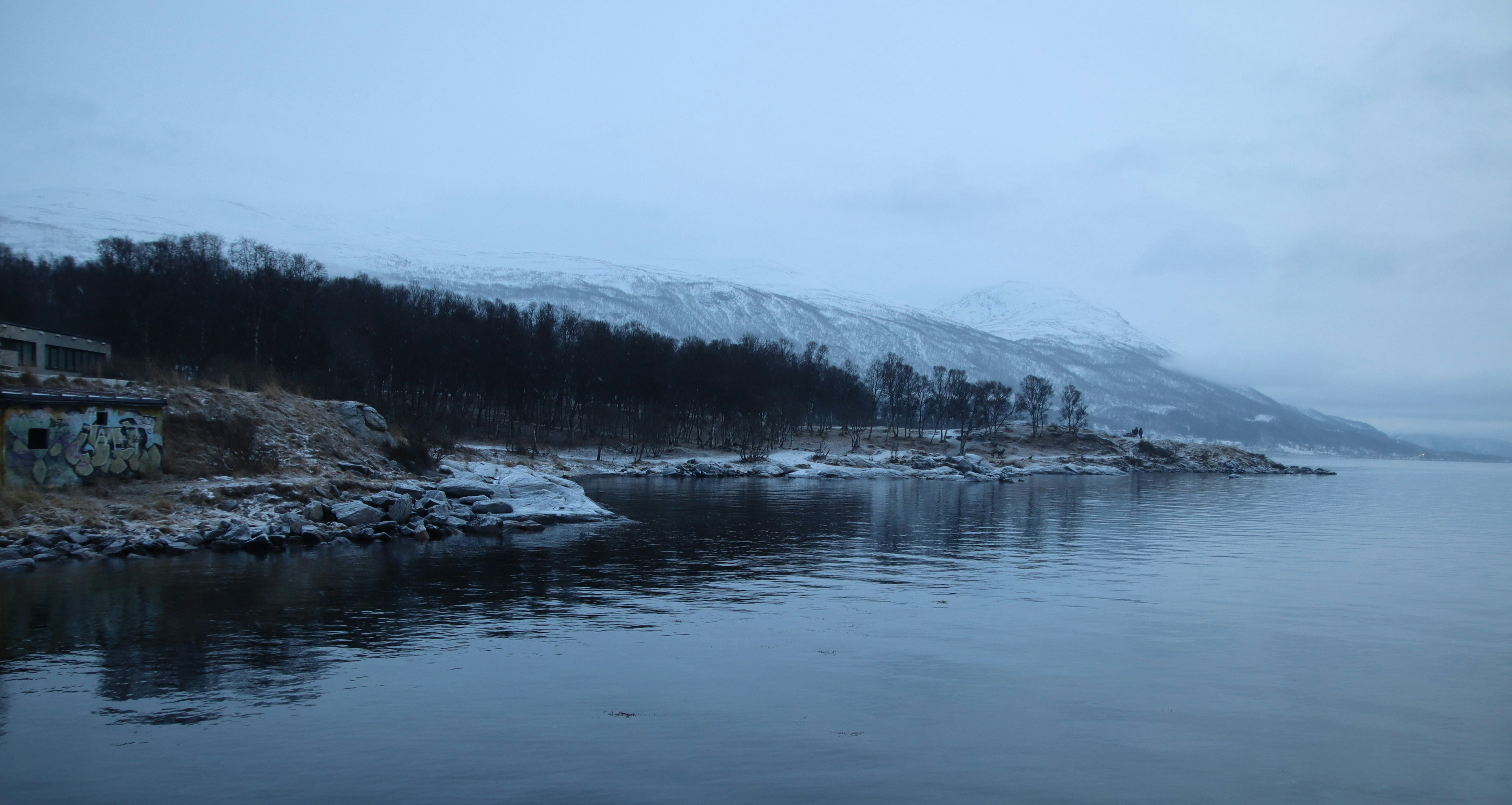 a body of water surrounded by snow covered mountains