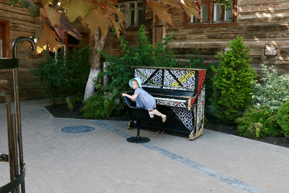 a man sitting at a piano in front of a house