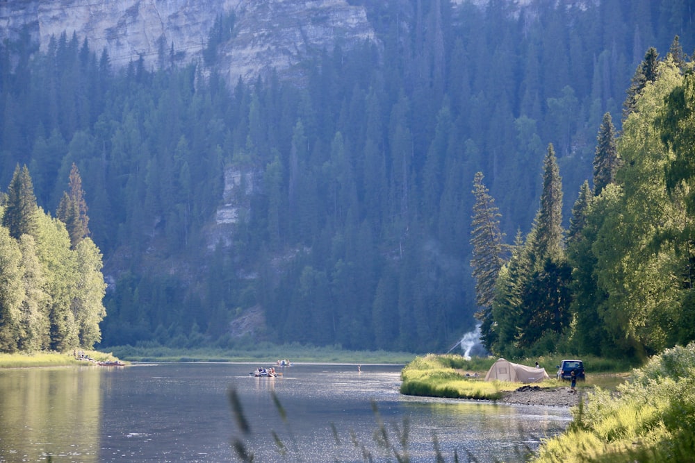 a lake surrounded by trees and a mountain in the background