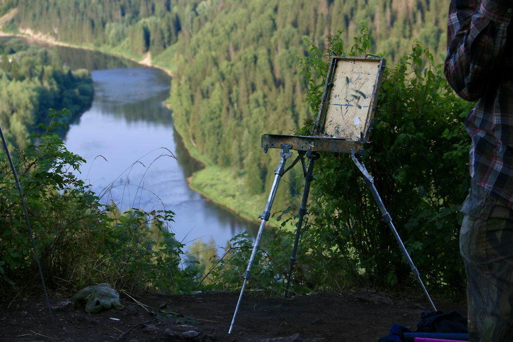 a man standing next to an easel with a painting on it