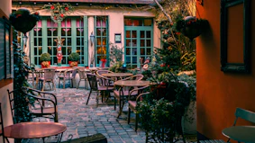a courtyard with tables and chairs and potted plants