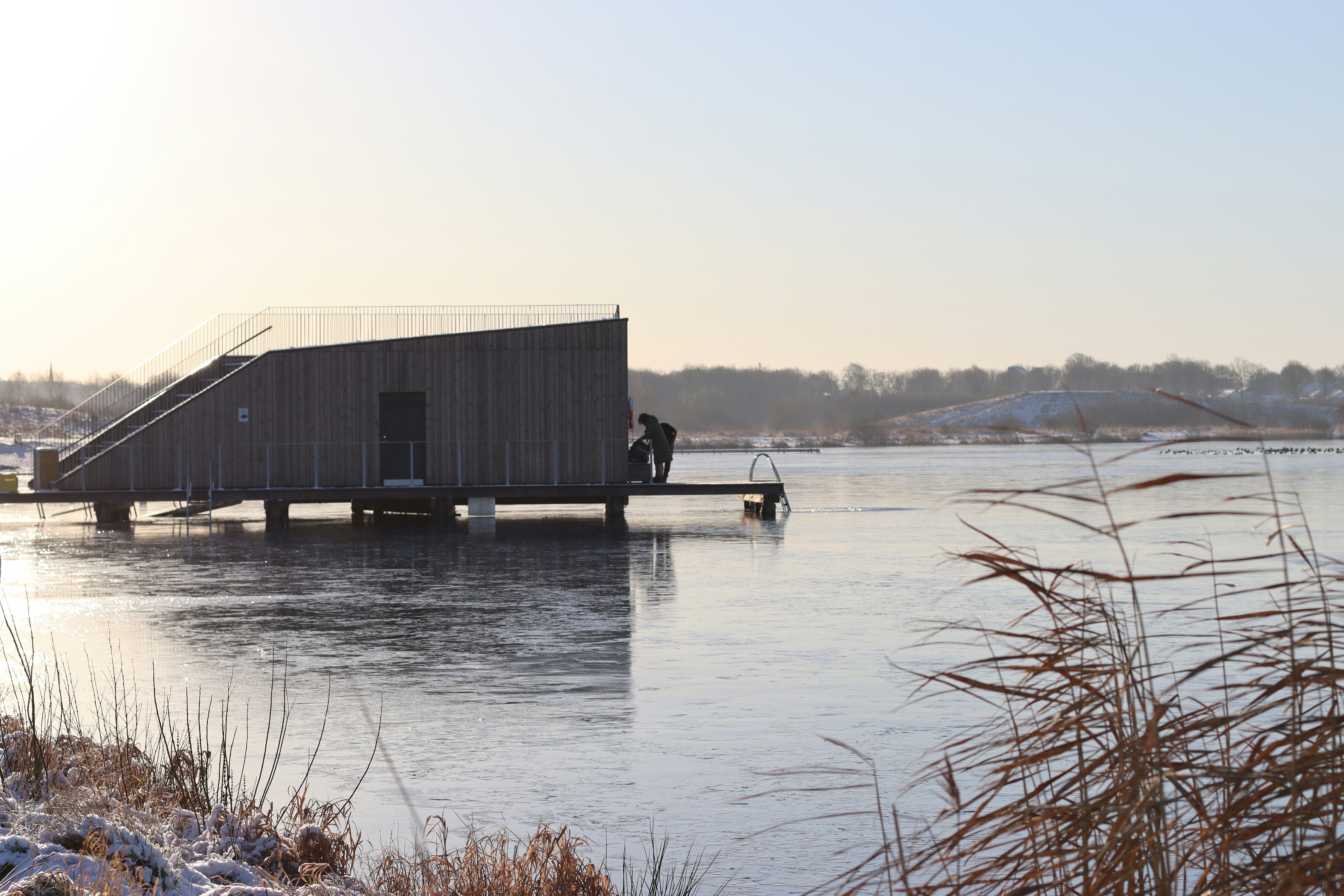 a man standing on a dock next to a body of water