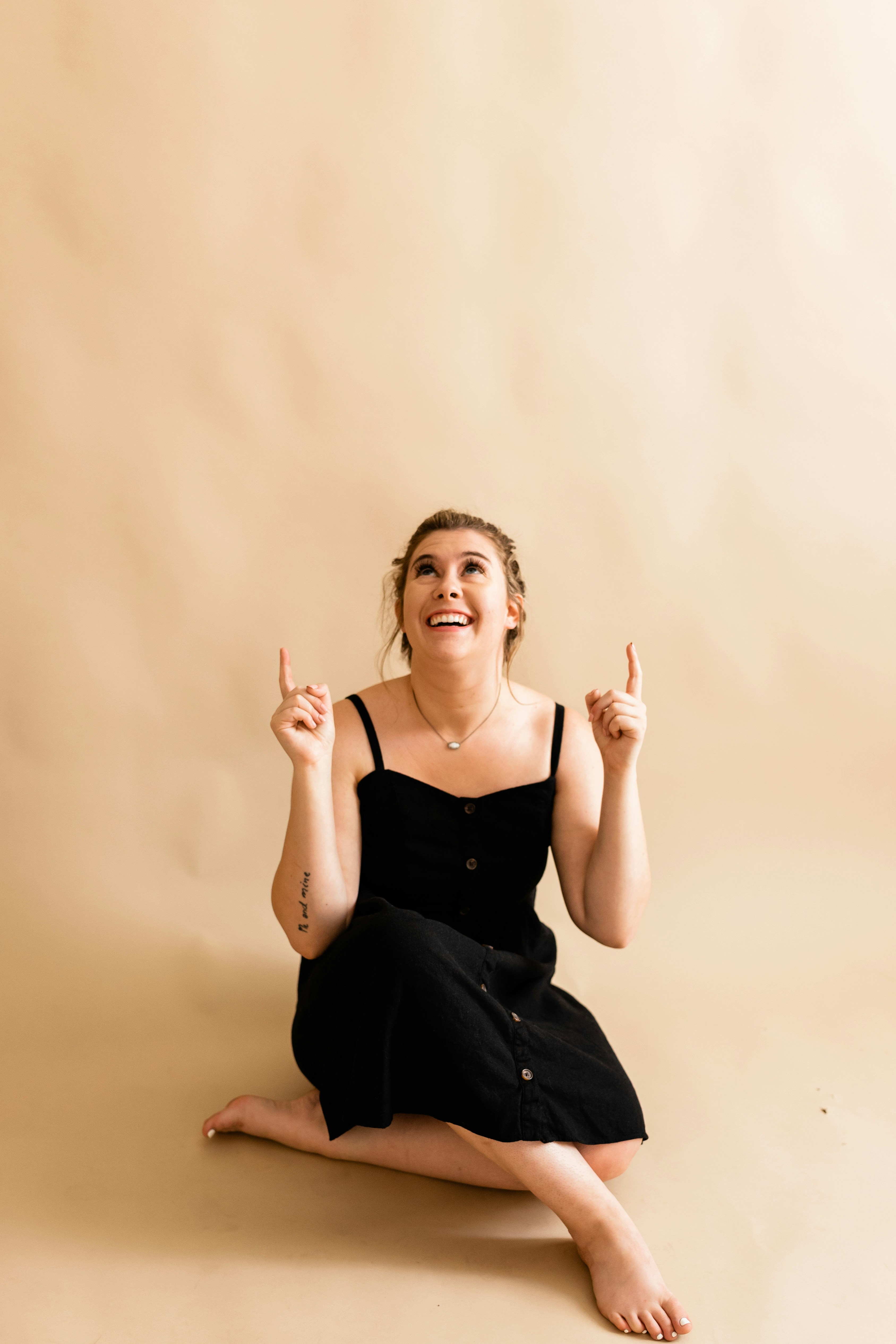 A woman in a black dress sitting on the floor photo – Free Human Image ...