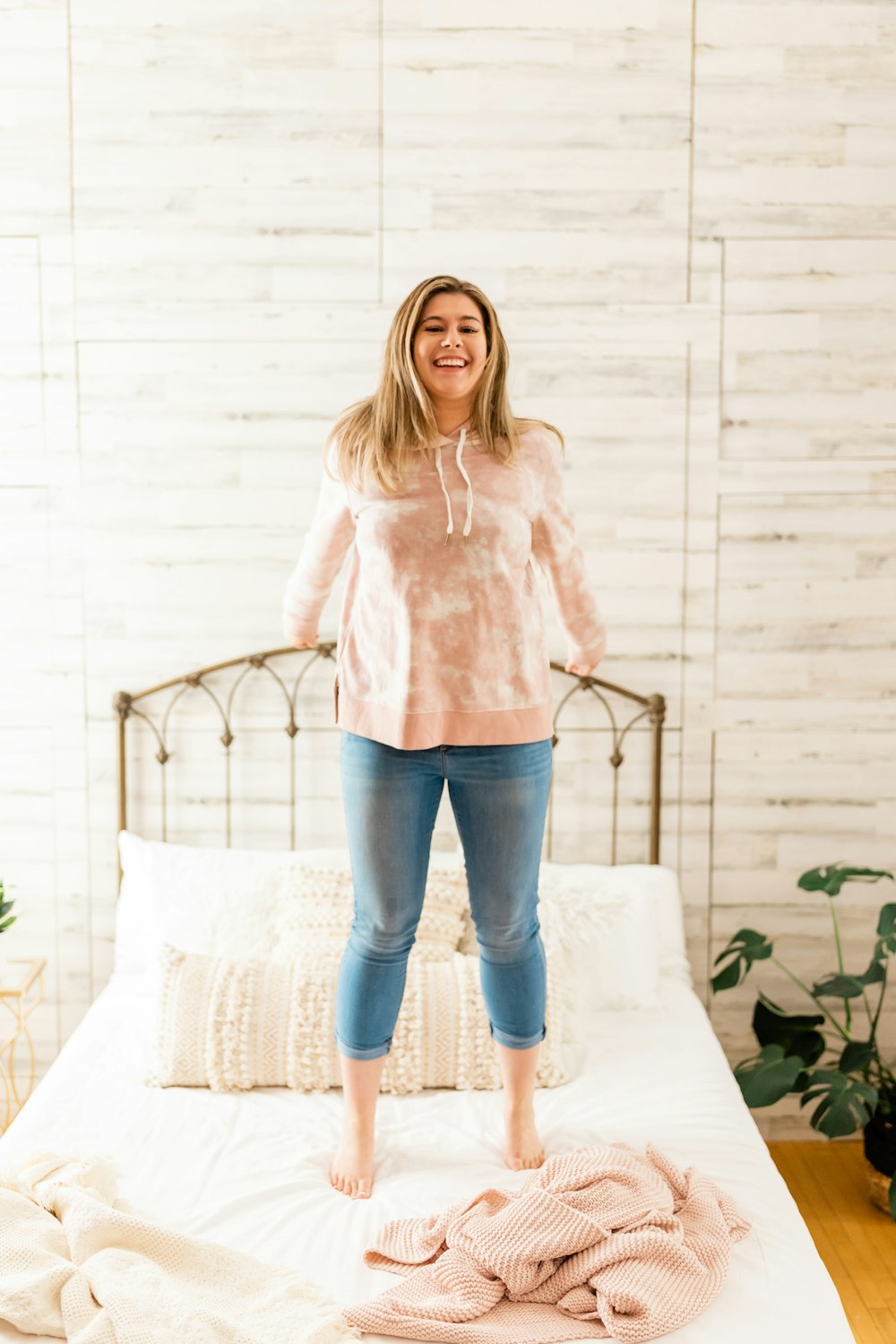 a woman standing on top of a bed