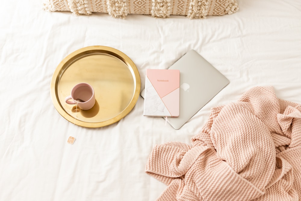 a bed with a laptop and a gold tray on top of it